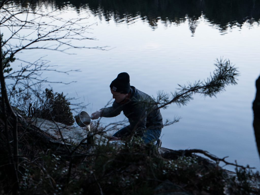 Man pouring hot water and making a beverage in nature