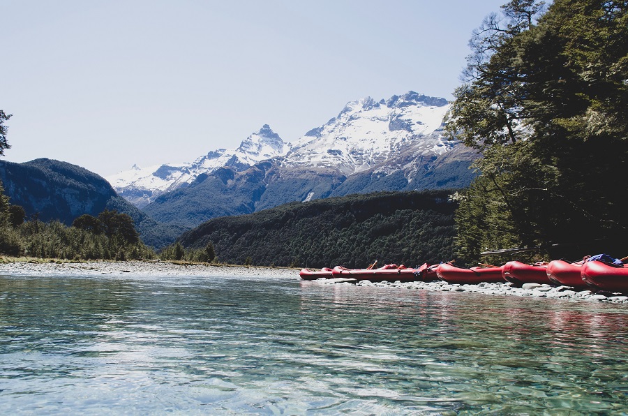 Red rafting boats in front of the snowy mountain