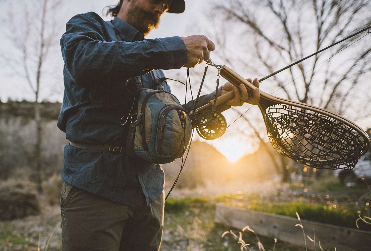 man holding a fishing rod and landing net