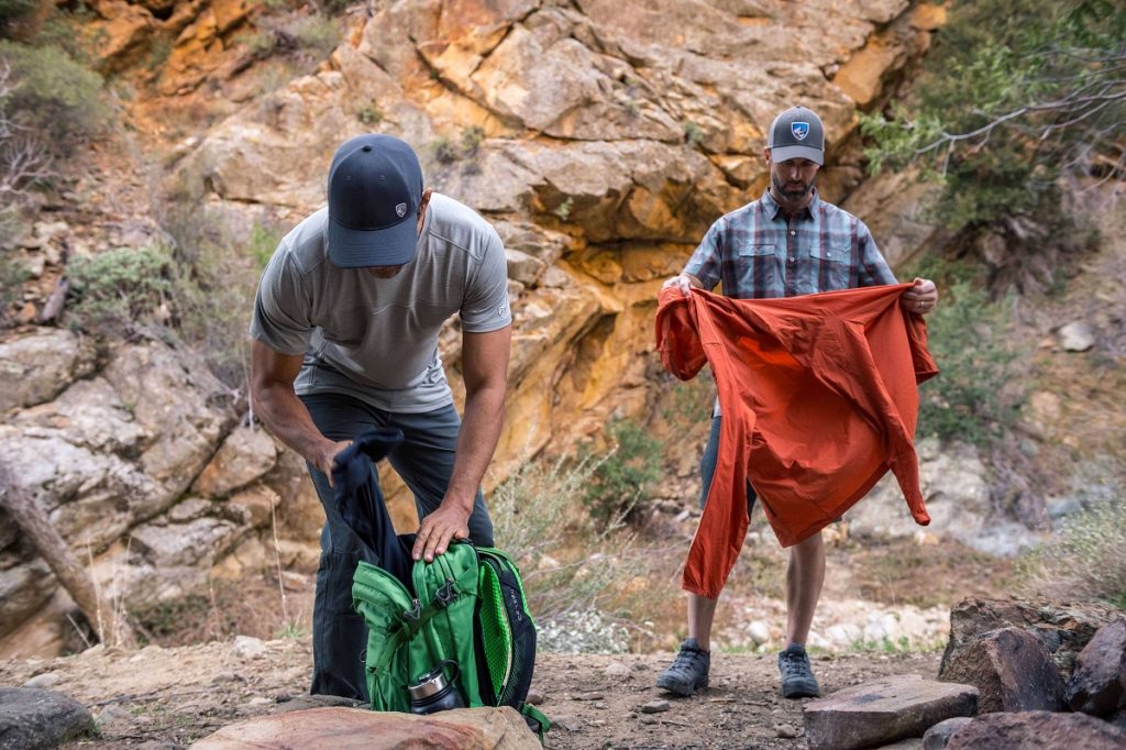 two men holding hiking gear
