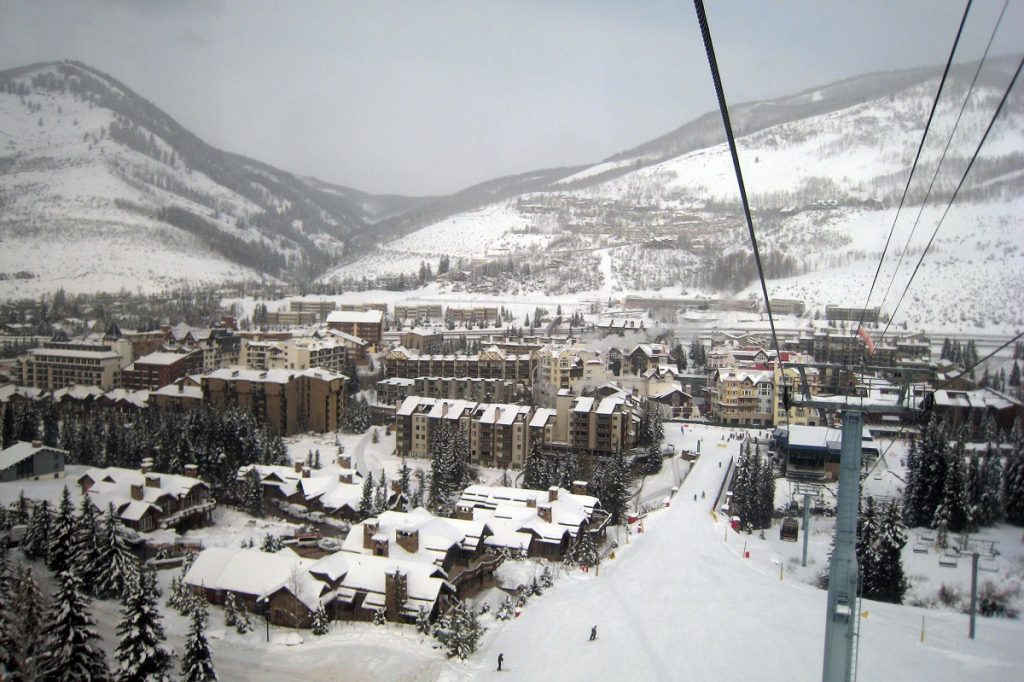 snow covered town with snowy mountains in the back during daytime