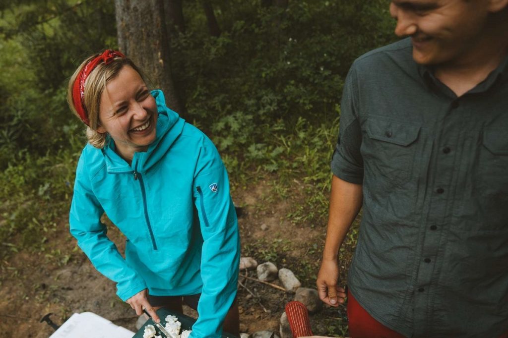 woman in K&Uuml;HL jacket cutting vegetables while camping