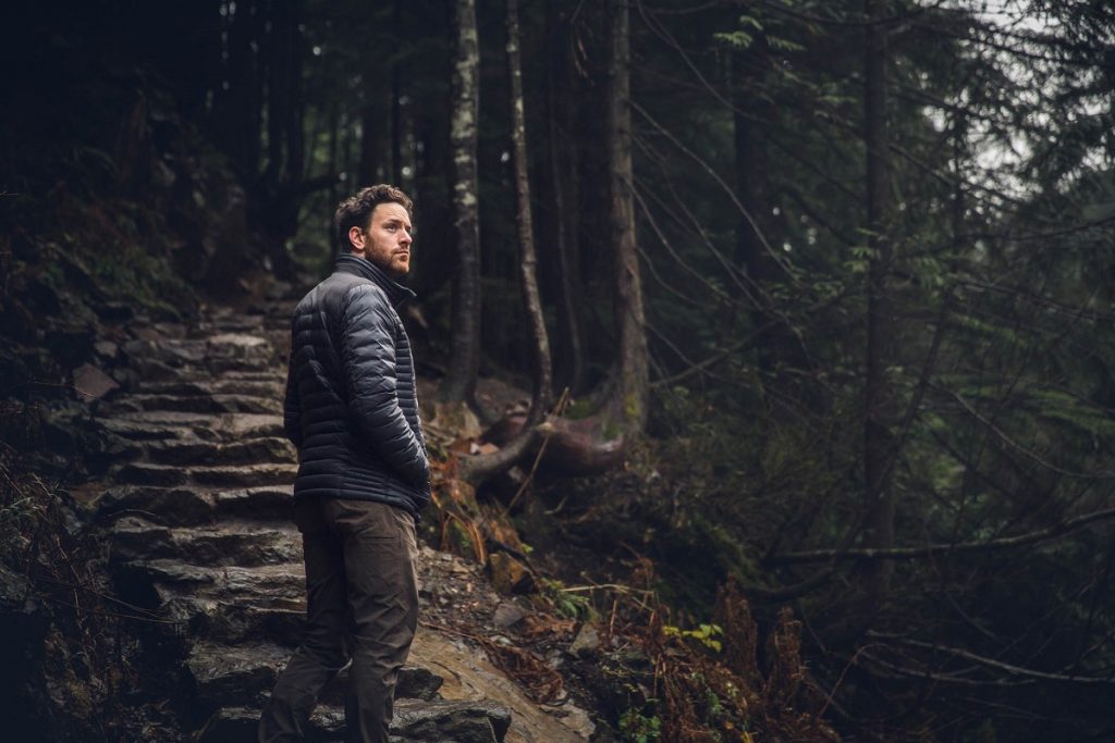 man in K&Uuml;HL pants and K&Uuml;HL jacket in the woods