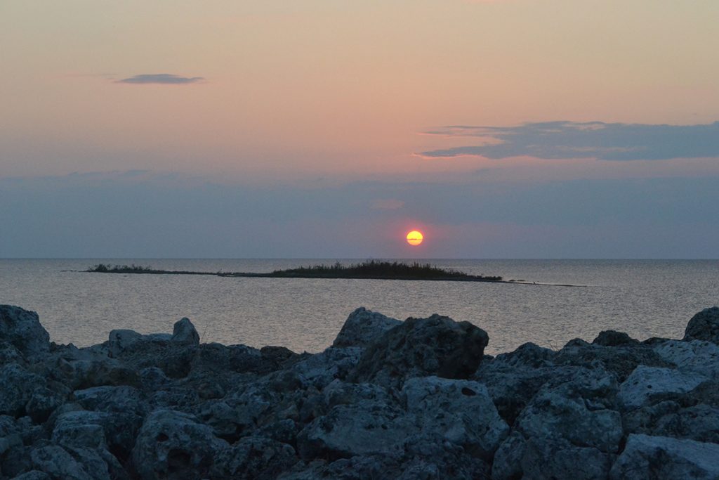 sun setting over body of water
