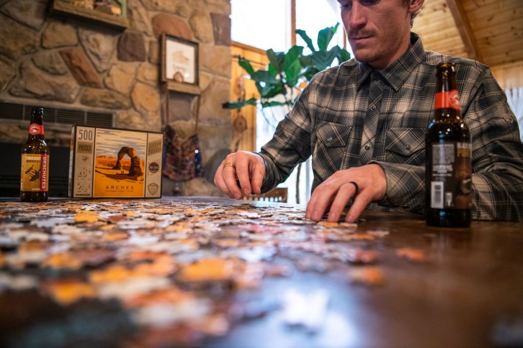 man in blue K&Uuml;HL flannel doing a puzzle