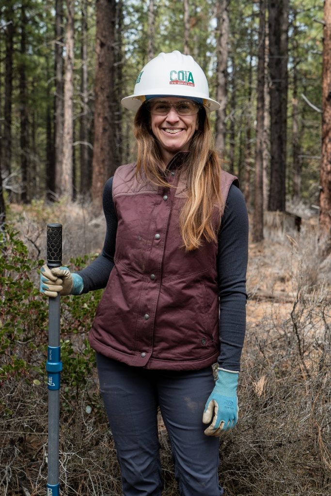 A woman wearing KUHL Clothing resting from making mountain bike trail